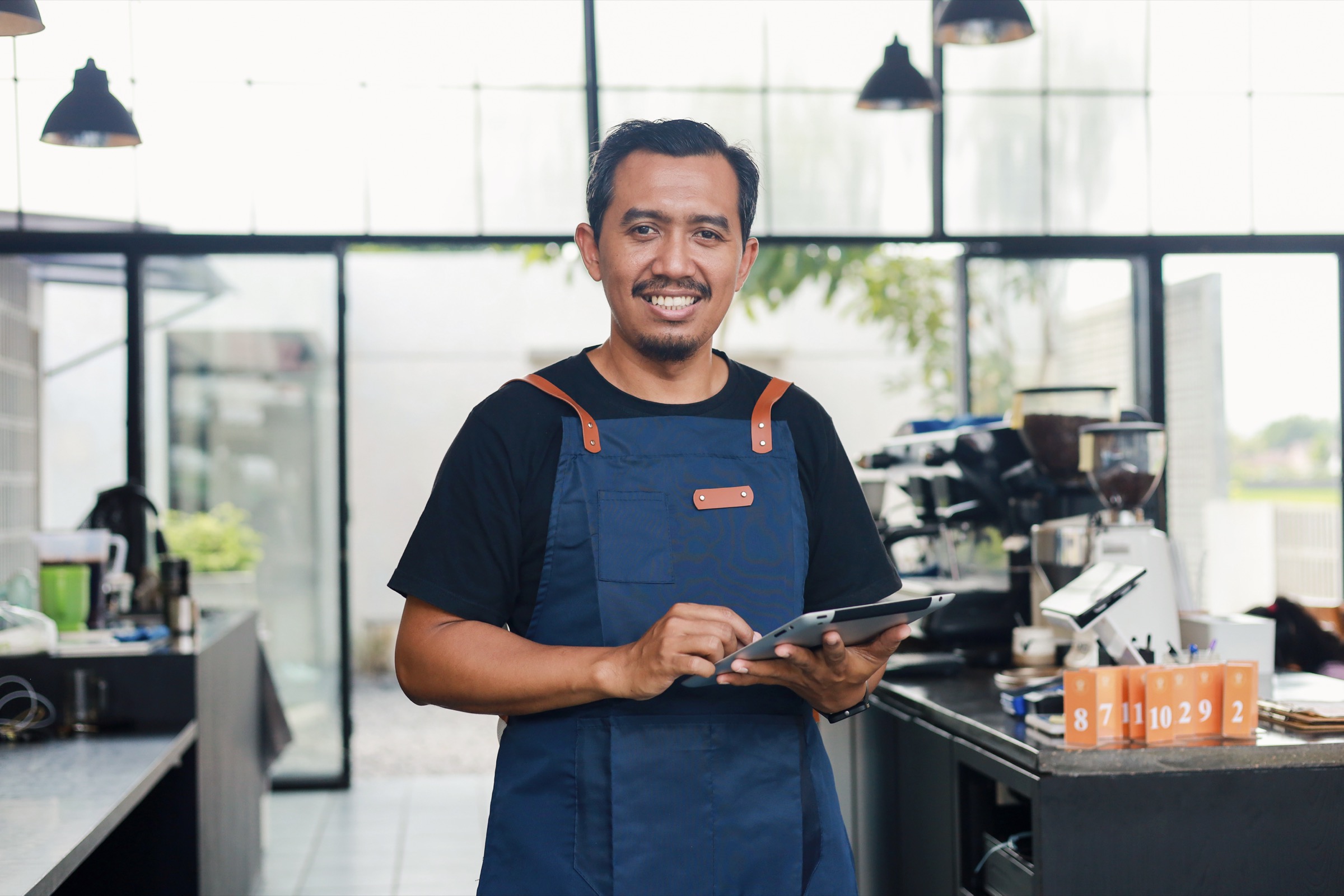 Restaurant owner managing his business on a tablet